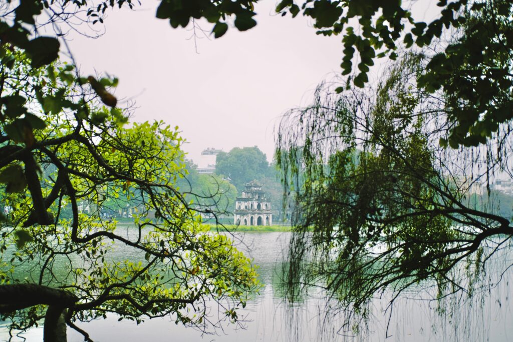 Hoan Kiem Lake in Hanoi with the red Huc Bridge at sunrise.